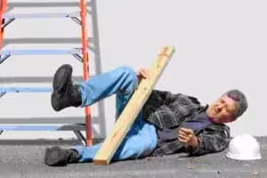 Doctor examining a worker’s injured hand in a clinical setting, illustrating workplace injury consultation.